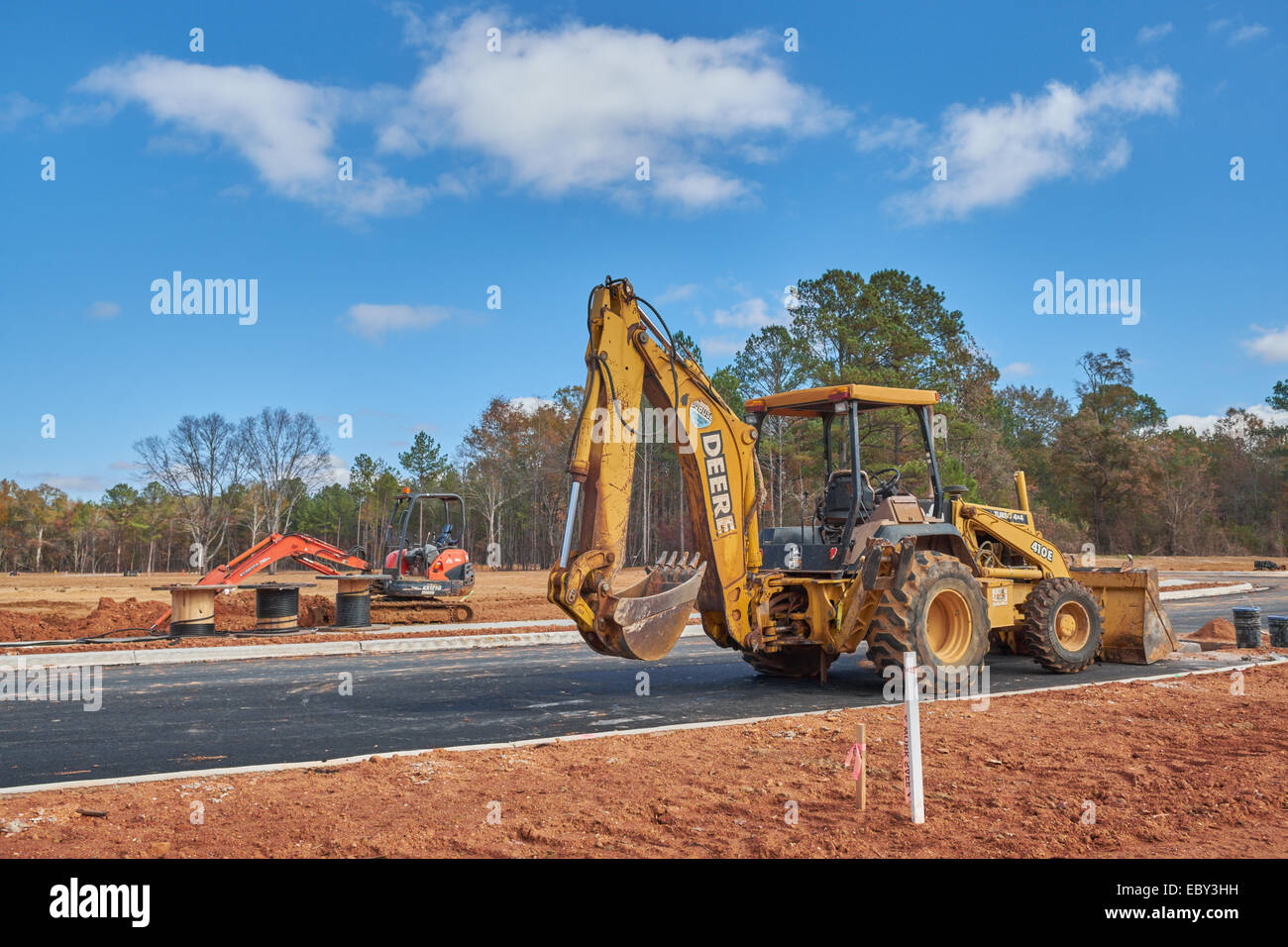 Ein John Deere Tieflöffel/Frontlader im Vordergrund mit einem kleineren Kubota Bagger im Hintergrund auf einer Baustelle, Hecht Straße, Alabama, USA. Stockfoto