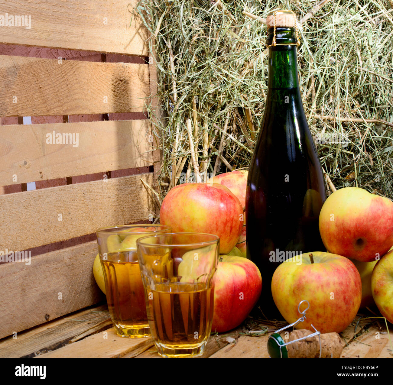 Flasche Cidre mit einigen Äpfeln und Stroh Stockfoto