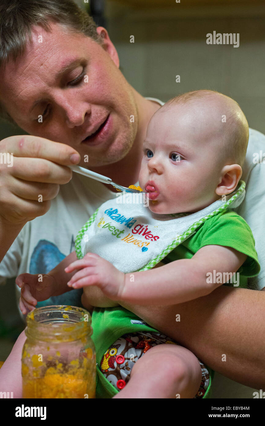 Denver, Colorado - Adam Hjermstad Sr. füttert seinen vier Monate alten Sohn, Adam Jr. Stockfoto
