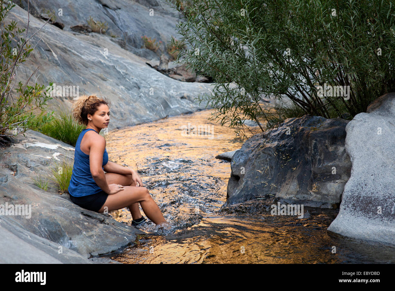 Weibliche Wanderer ruht In A Creek Stockfoto