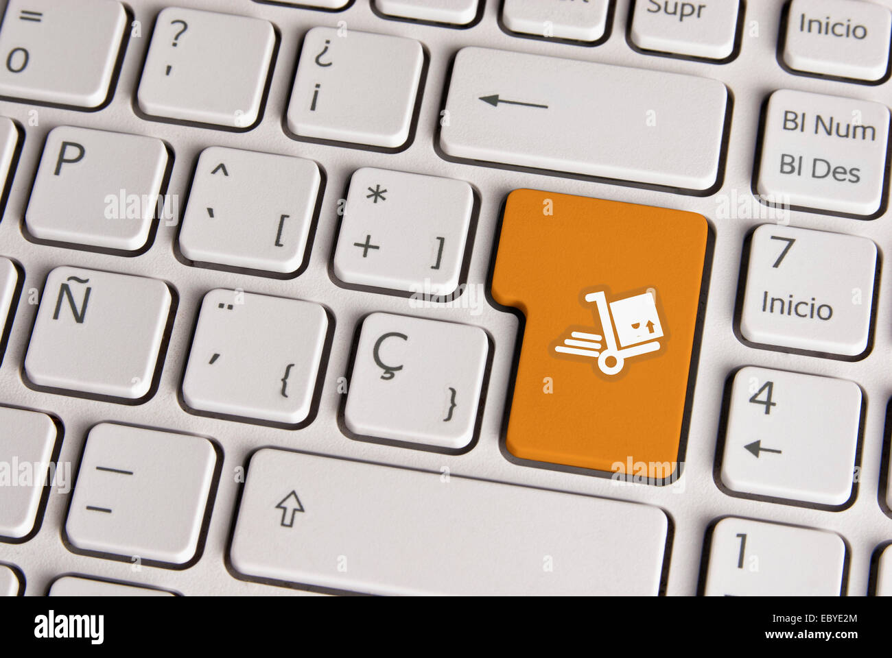 Spanische Tastatur mit Lieferung Versand Warenkorb-Icon über Schaltfläche "Goldgrund". Bild mit Beschneidungspfad für einfachen Wechsel der Schlüssel Stockfoto
