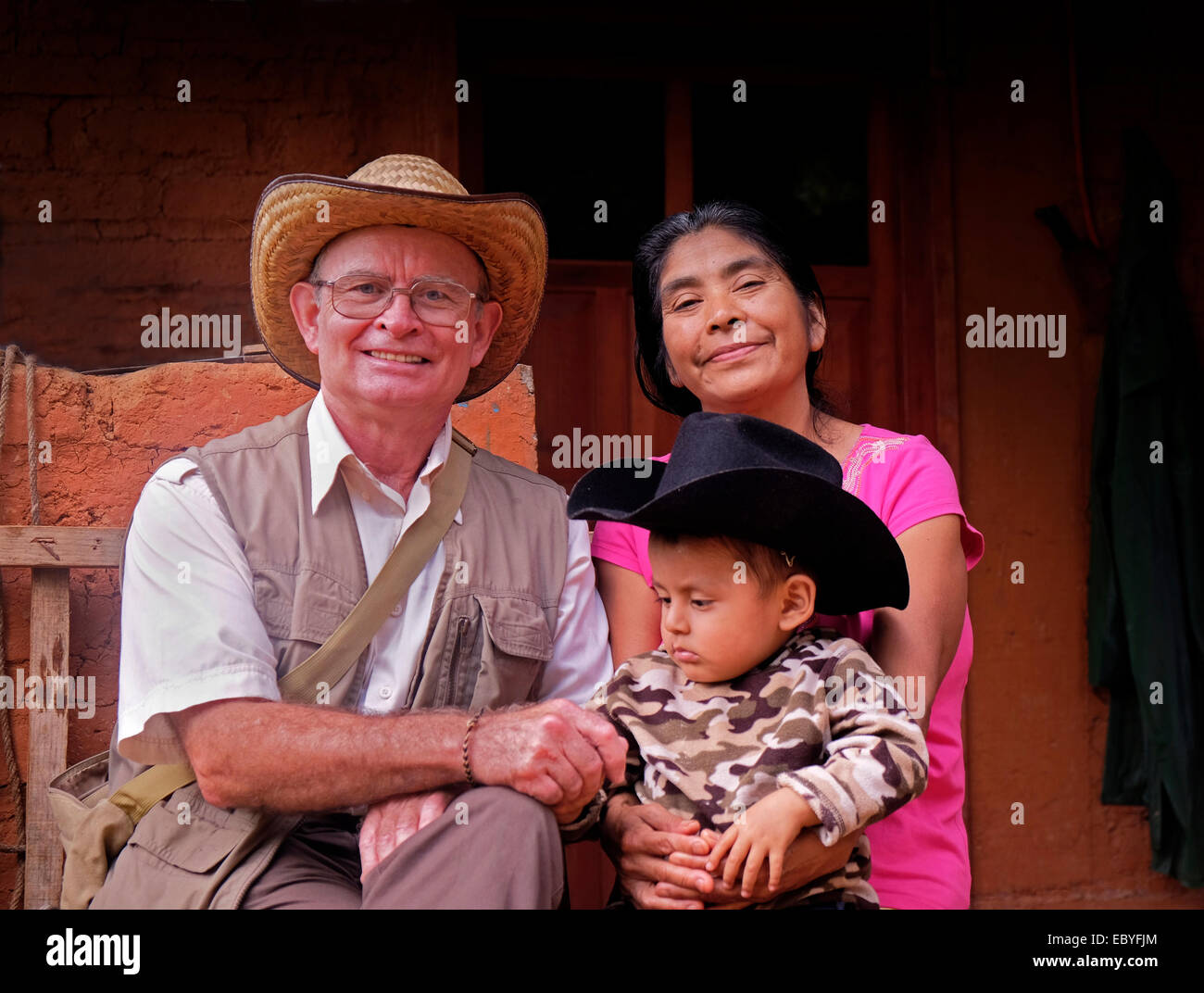 Besucher mit einer einheimischen Frau und Kind in einem Zapoteken-Dorf in Oaxaca, Mexiko Stockfoto