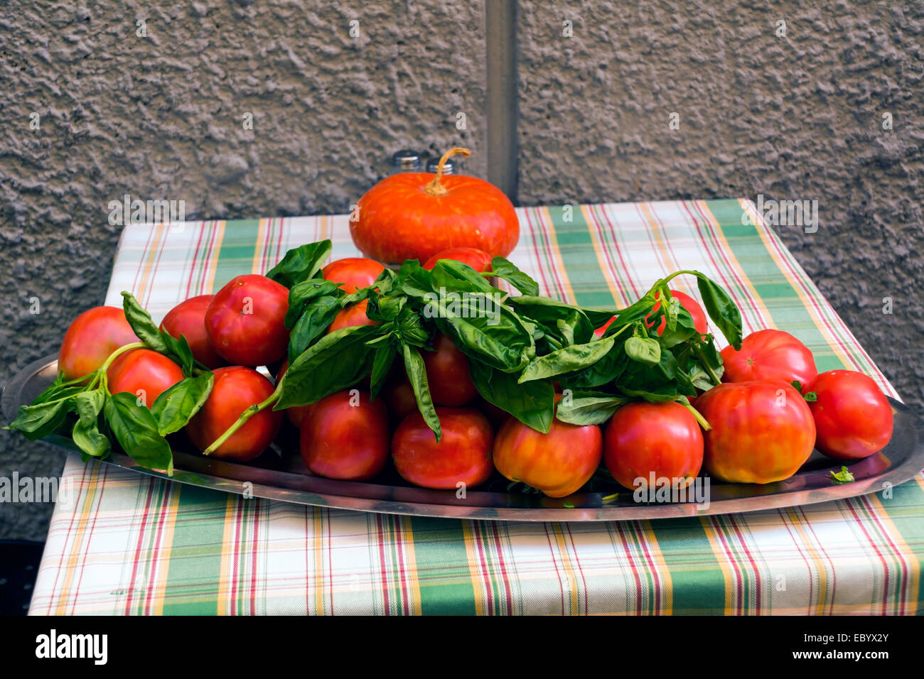 Tomaten links abgedeckt draußen in Basilikum, Basilikum Geschmack einfließen zu lassen. Lokal gewachsen und unterschiedlichen Größen. Stockfoto