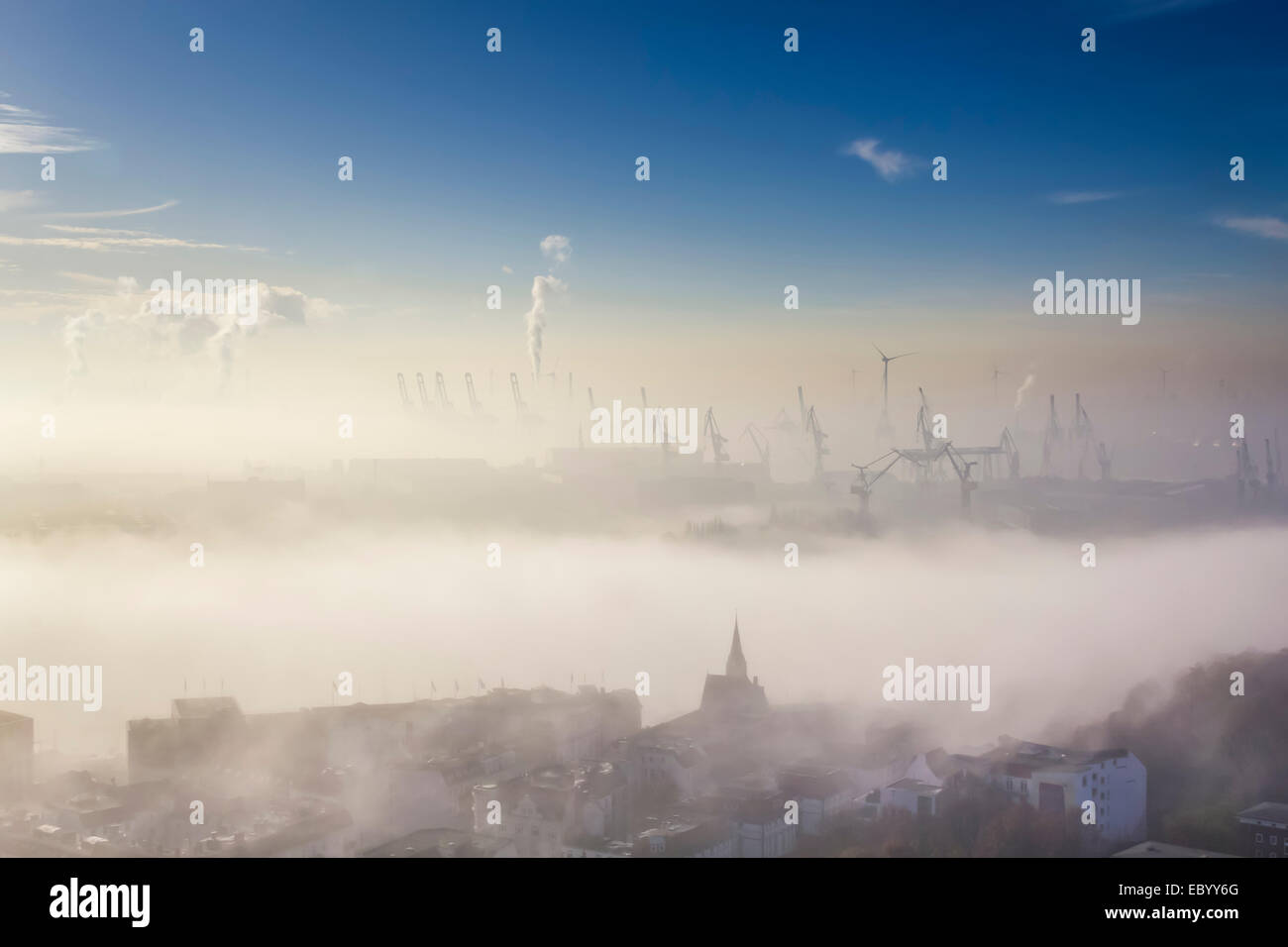 Luftaufnahme eines Hafens mit Kranen ragte aus dichtem Nebel Stockfoto