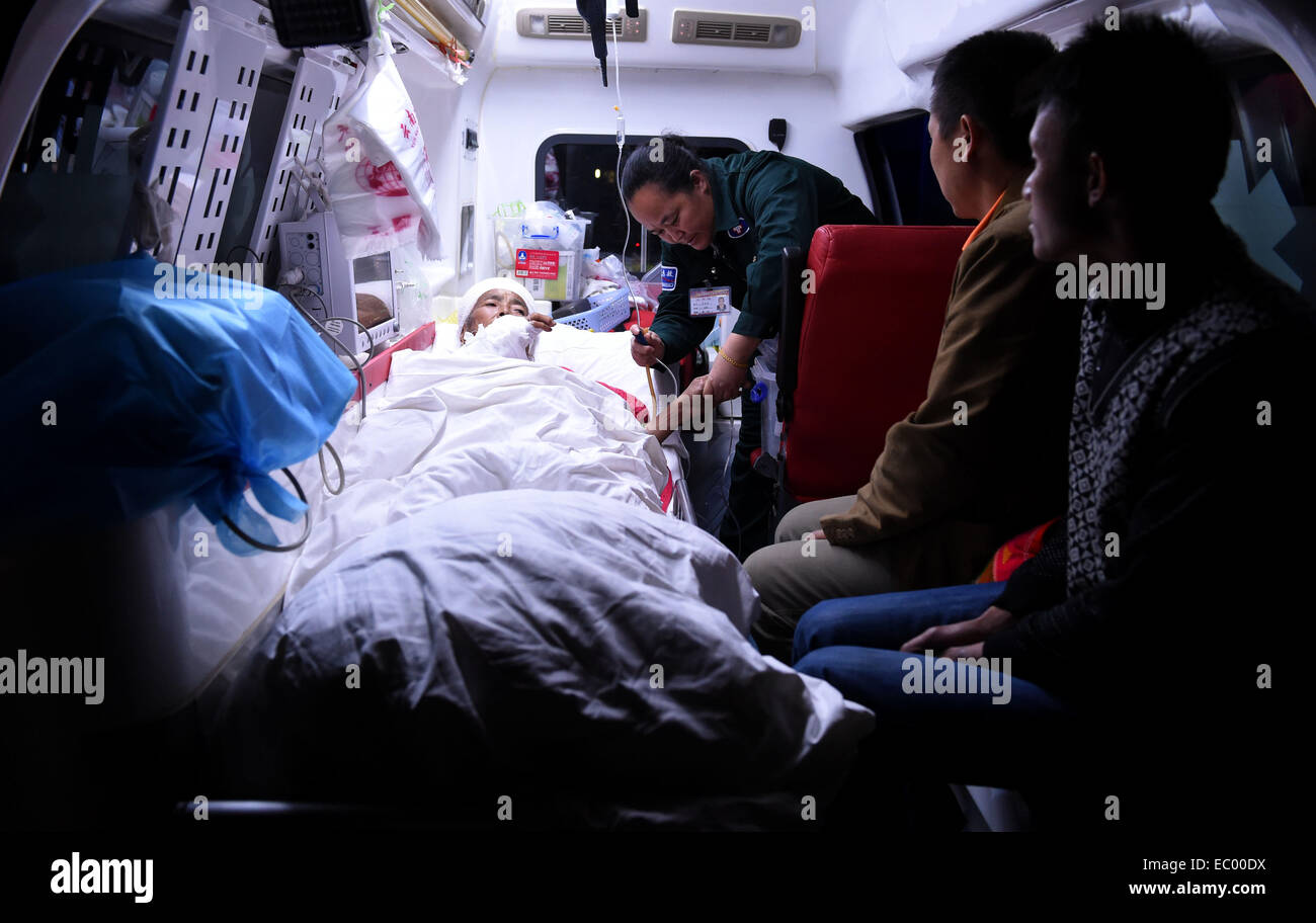 Jinggu, chinesischen Provinz Yunnan. 6. Dezember 2014. DAO Honglian, eine 65 jährige Frau die Dai ethnische Gruppe wird in einem Krankenwagen in ein örtliches Krankenhaus für die Behandlung im Jinggu der Dai und Yi autonome Grafschaft, der südwestlichen chinesischen Provinz Yunnan, 6. Dezember 2014 durchgeführt. Eine Erdbeben der Stärke 5,9 erschütterte Jinggu um 18:20 am Samstag, ein toter und acht Verletzte gefordert. © Lin Yiguang/Xinhua/Alamy Live-Nachrichten Stockfoto
