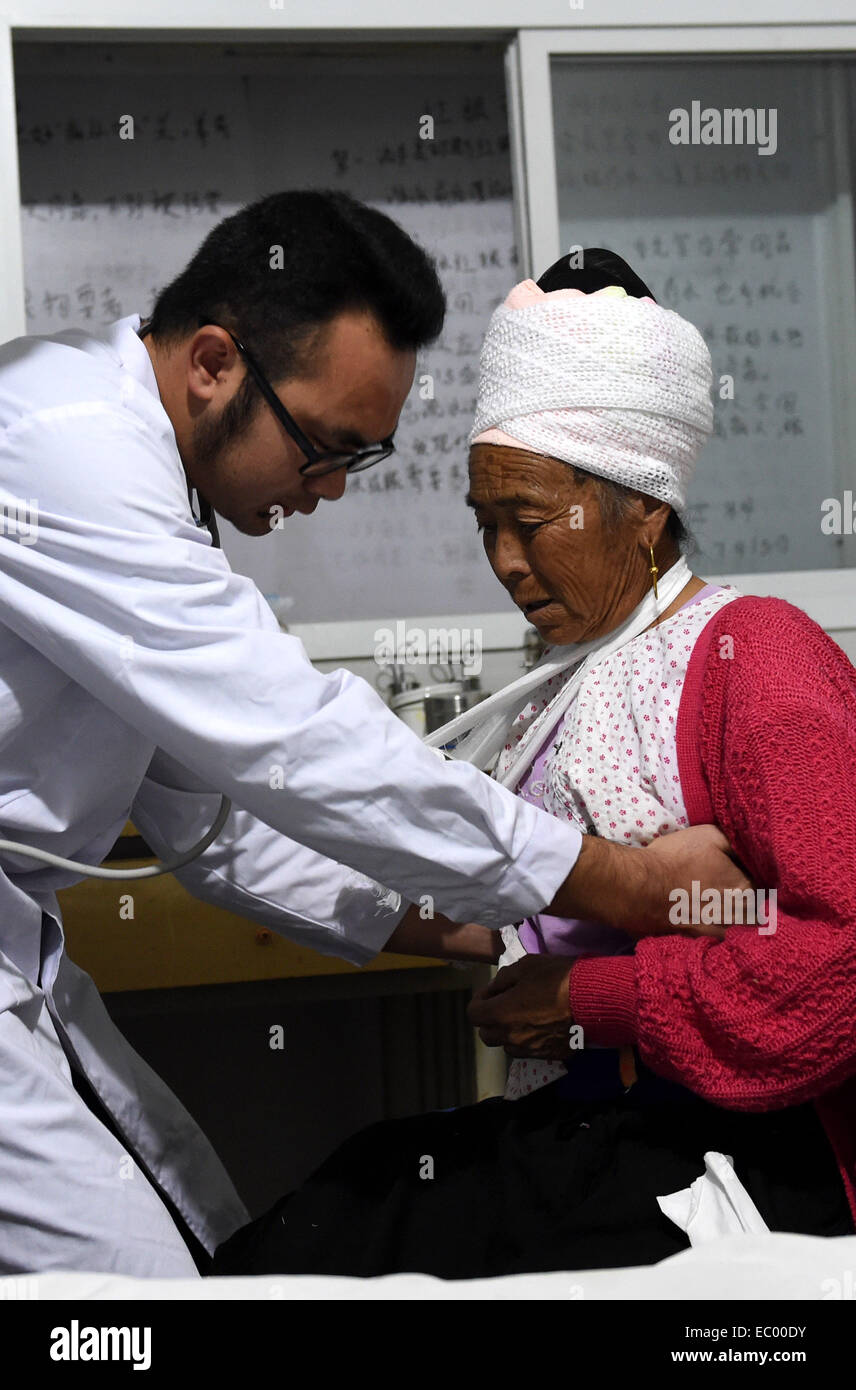 Jinggu, chinesischen Provinz Yunnan. 6. Dezember 2014. DAO Honglian, eine 65 jährige Frau die Dai ethnische Gruppe erhält Behandlung in einem Krankenhaus in Jinggu der Dai und Yi autonome Grafschaft, der südwestlichen chinesischen Provinz Yunnan, 6. Dezember 2014. Eine Erdbeben der Stärke 5,9 erschütterte Jinggu um 18:20 am Samstag, ein toter und acht Verletzte gefordert. © Lin Yiguang/Xinhua/Alamy Live-Nachrichten Stockfoto