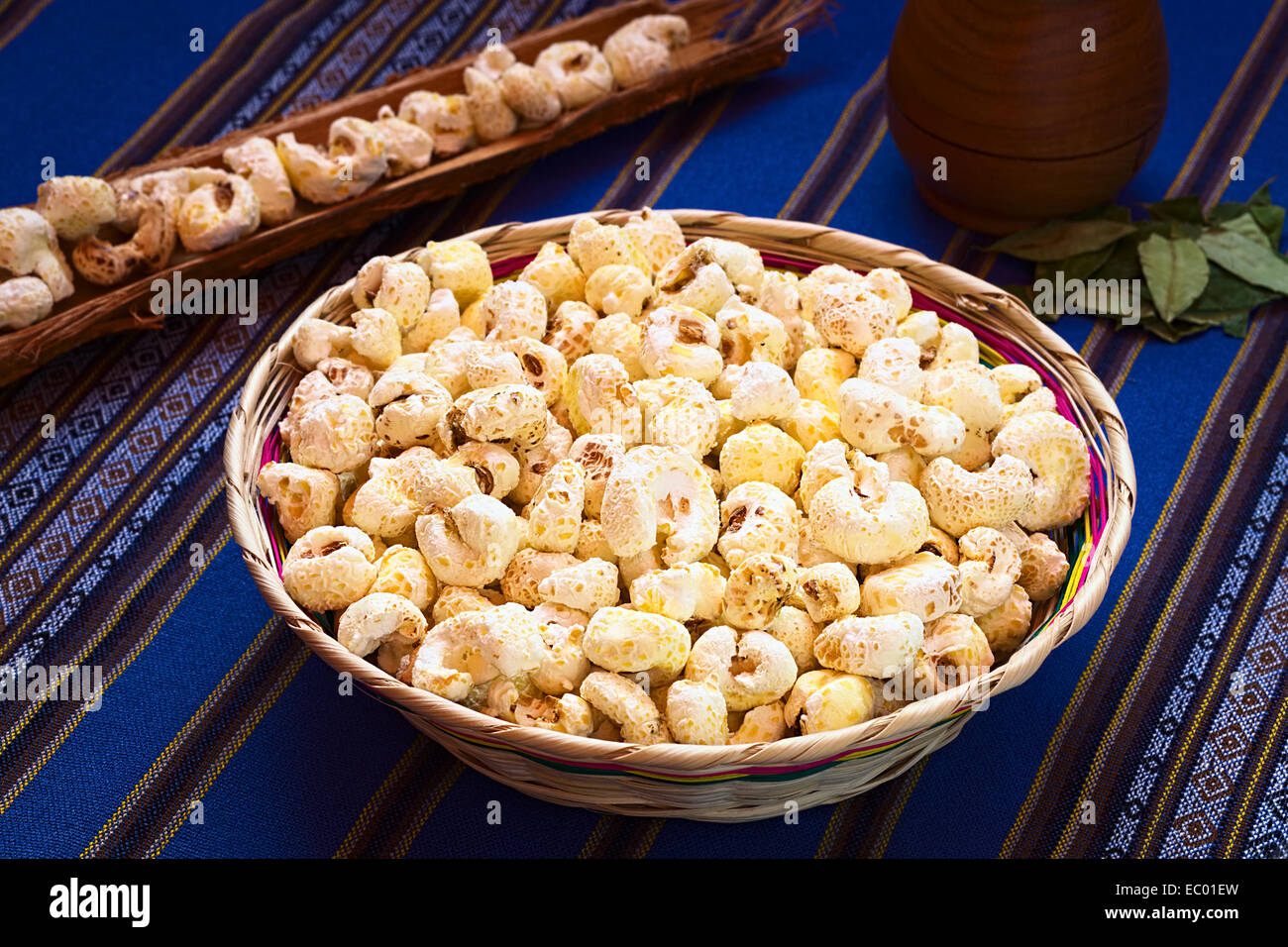 Gesüßte knallte weißen Mais genannt Pasancalla gegessen als Snack in Bolivien serviert in einem geflochtenen Korb mit Coca-Tee in den Rücken Stockfoto