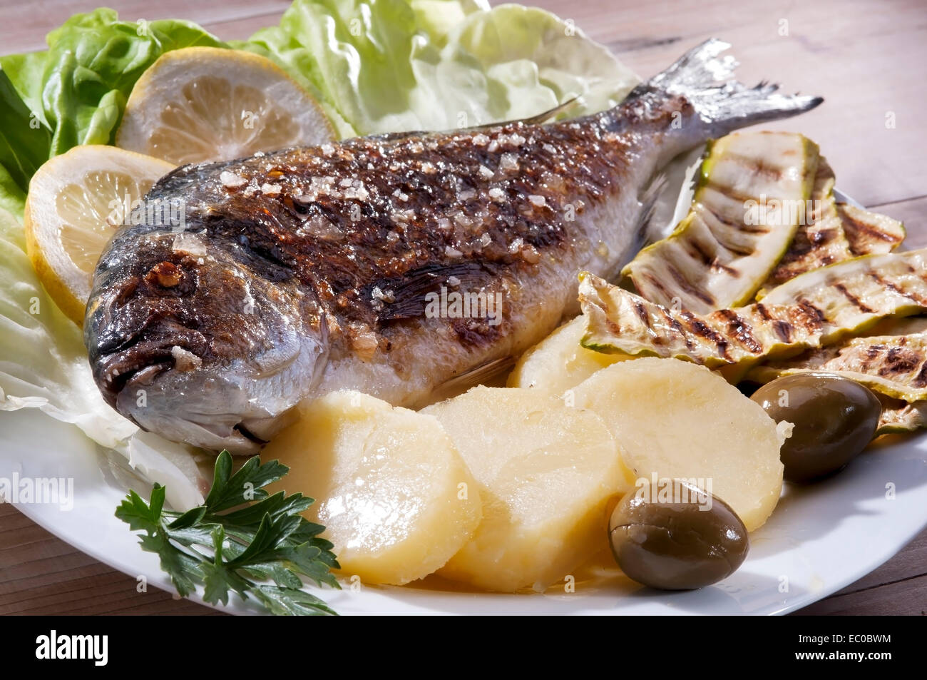 Köstlichen gegrillten Fisch Brassen, Mittelmeerfisch, mit Salzkartoffeln und gegrillten zucchini Stockfoto