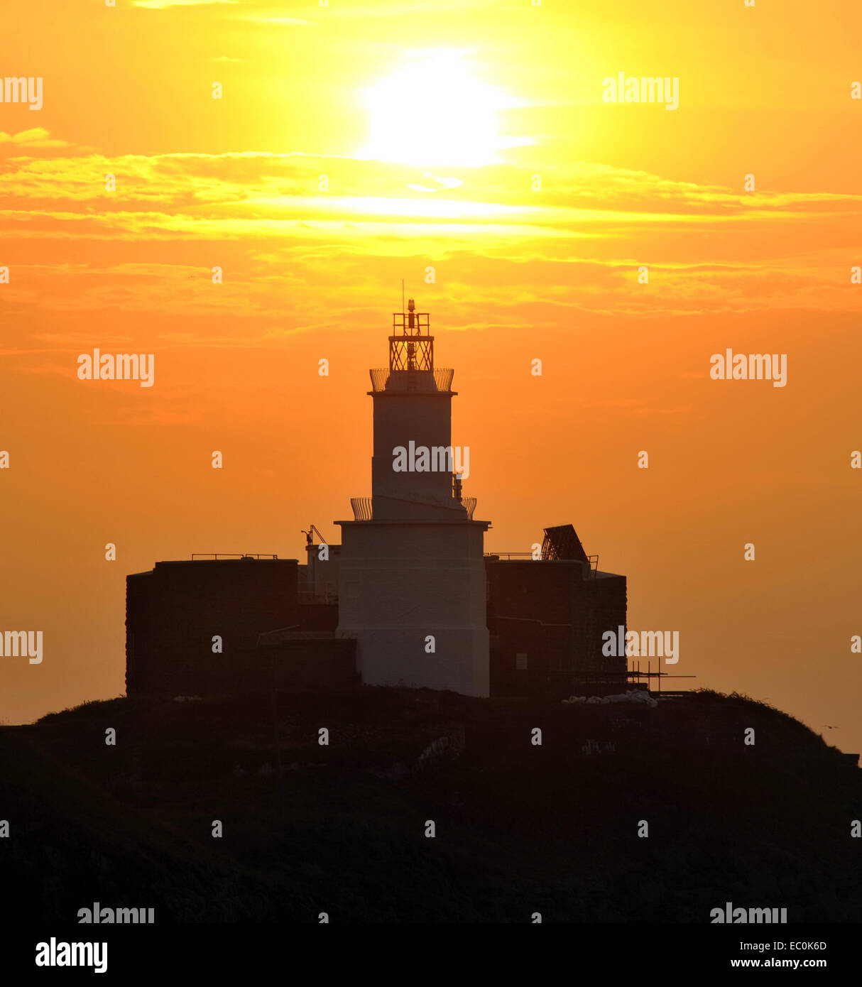 Mumbles Leuchtturm bei Sonnenaufgang mit goldenen Sonne über dem Light Tower. Mumbles war der beste Ort in Wales 2018 zu Leben gestimmt. Stockfoto