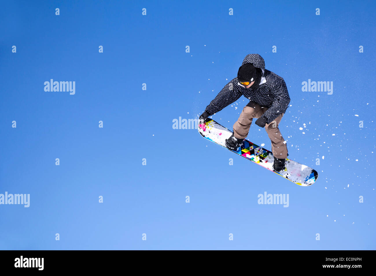 Snowboarder durch Luft springen auf blauen Himmelshintergrund Stockfoto