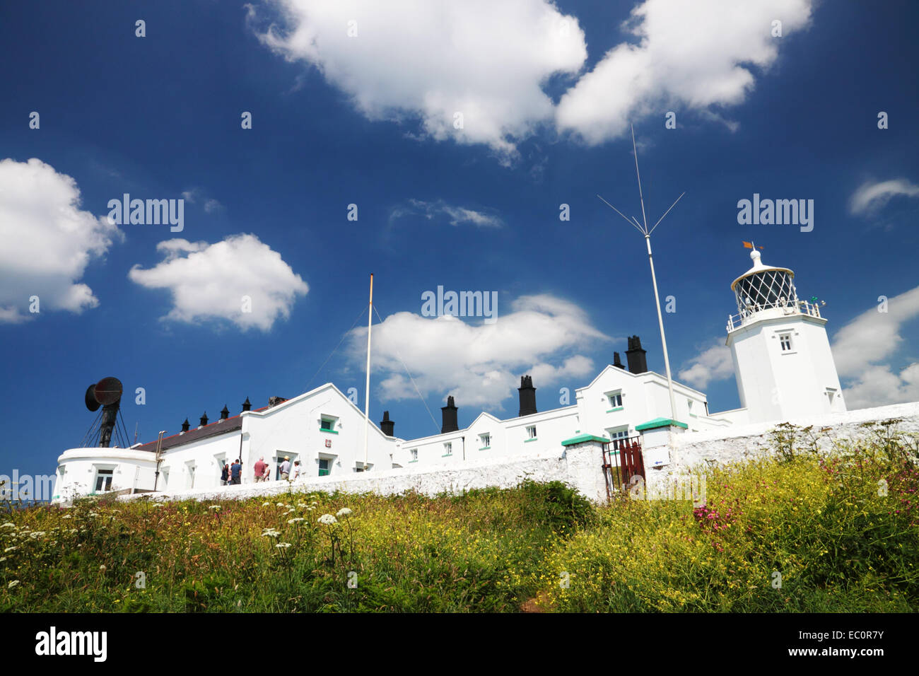 Ein weiß lackierter Leuchtturm mit angrenzenden Cottages und einem schwarzen Nebelhorn. Stockfoto