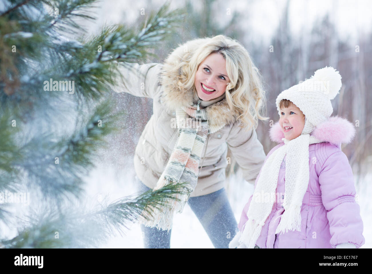 Glückliche Eltern und Kind spielt mit Schnee im Winter im freien Stockfoto