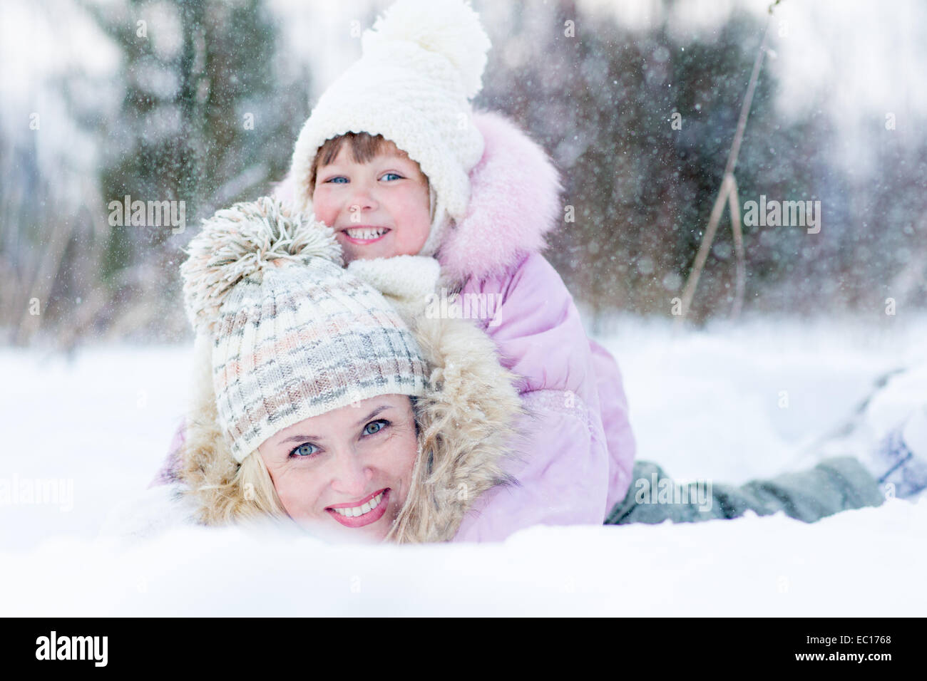 Glückliche Eltern und Kind spielt mit Schnee im Winter im freien Stockfoto