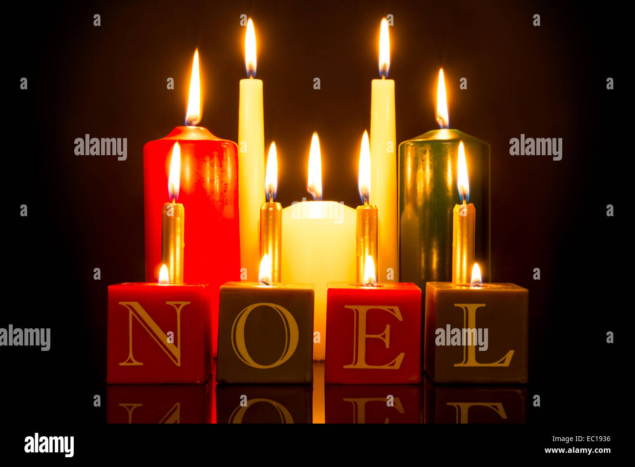 NOEL Kerzen vor einem schwarzen Hintergrund. Stockfoto