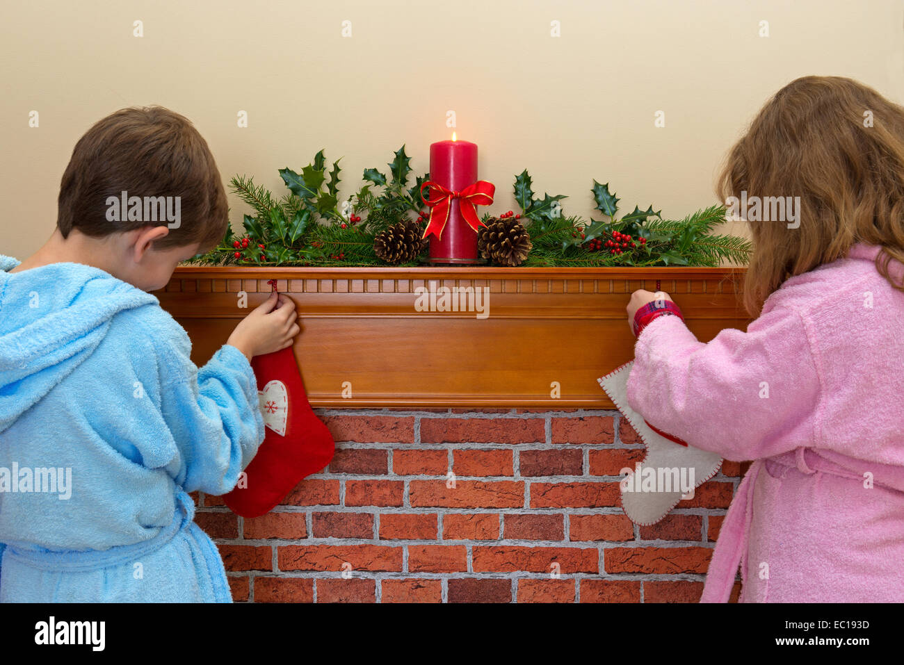 Ein Junge und ein Mädchen ihre Strümpfe über dem Kamin am Heiligabend Stockfoto