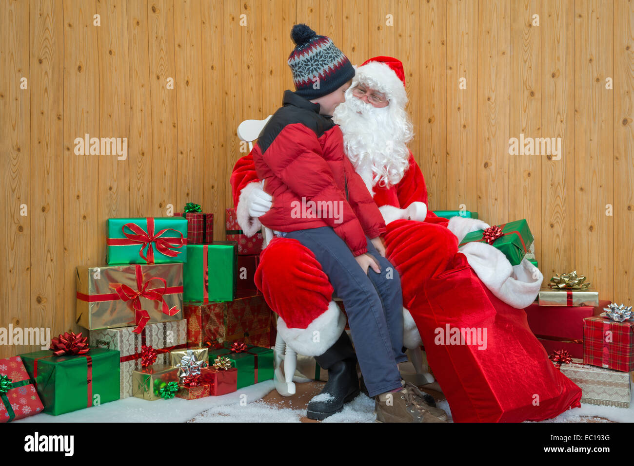 Ein Junge besucht Santa in seiner Grotte zu Weihnachten. Stockfoto