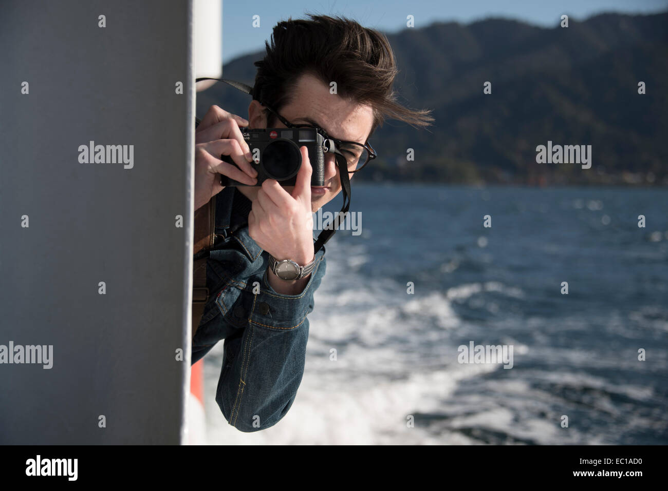 Junge männliche Fotografen auf hoher See. Stockfoto