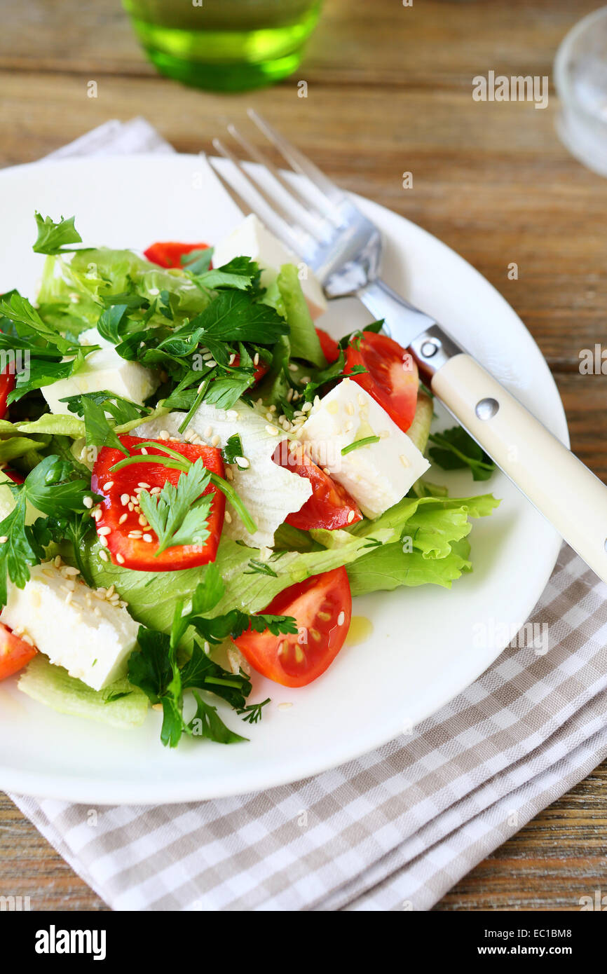 Salat mit Tomaten, Paprika und Käse auf einem Teller, Gemüse Stockfoto