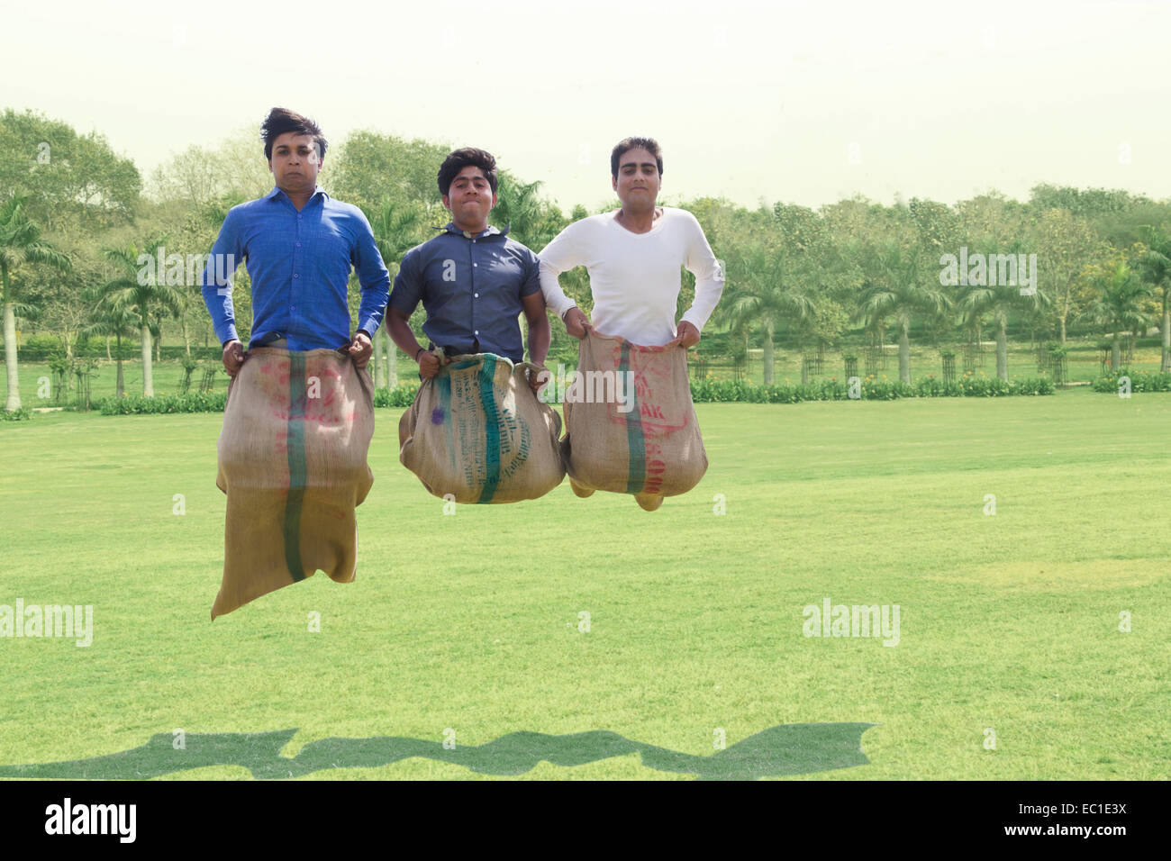 4 indische Freunde Parken spielen Sackhüpfen Stockfoto