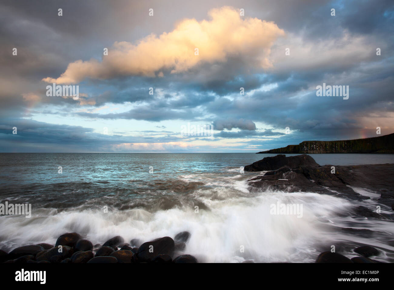 Sonnendurchflutetes Regenwolken über Greymare Rock bei Dämmerung Dunstanburgh Northumberland Küste England Stockfoto