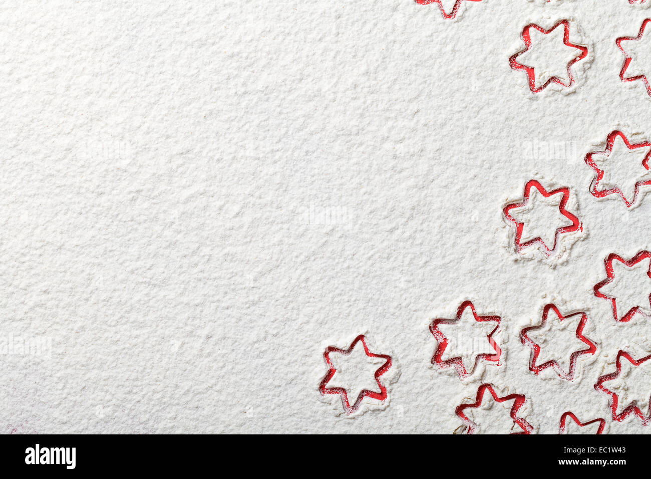 Weihnachtssterne auf Mehl Hintergrund mit Textfreiraum. Weißes Mehl sieht aus wie Schnee. Ansicht von oben Stockfoto