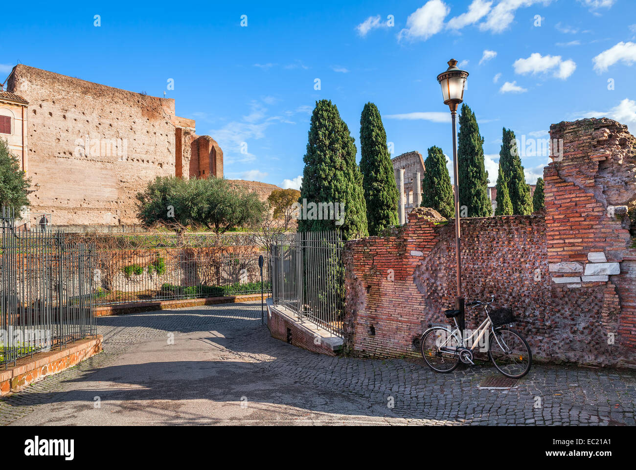 Stadt Fahrradständer stützte sich auf alte Mauer und Laternenpfahl auf schmalen Straße in Rom, Italien. Stockfoto