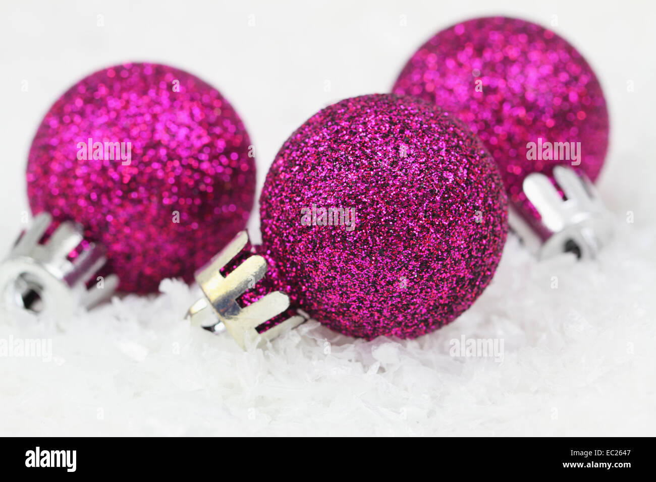 Lustige Weihnachtskarte mit lila Kugeln auf Schnee Stockfoto