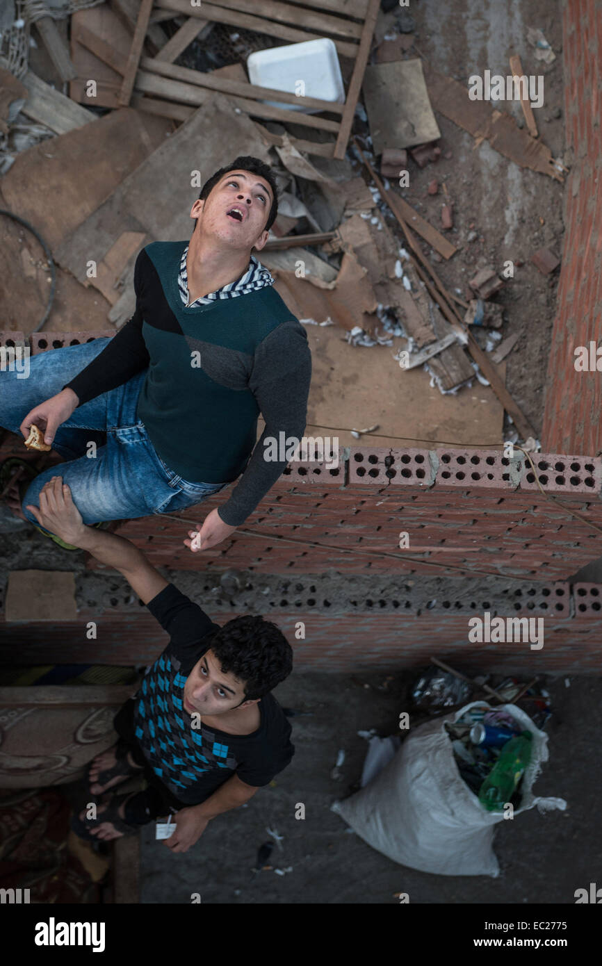 Kairo, Ägypten. 13. November 2014. Zwei junge Ägypter Nachschlagen bei Tauben fliegen im Mohandesen Bezirk, westlich von Kairo, Ägypten, am 13. November 2014. © Pan Chaoyue/Xinhua/Alamy Live-Nachrichten Stockfoto