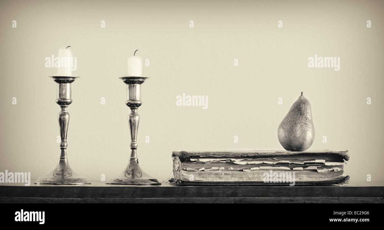 Stillleben mit Kerzen, Buch und Birne Stockfoto