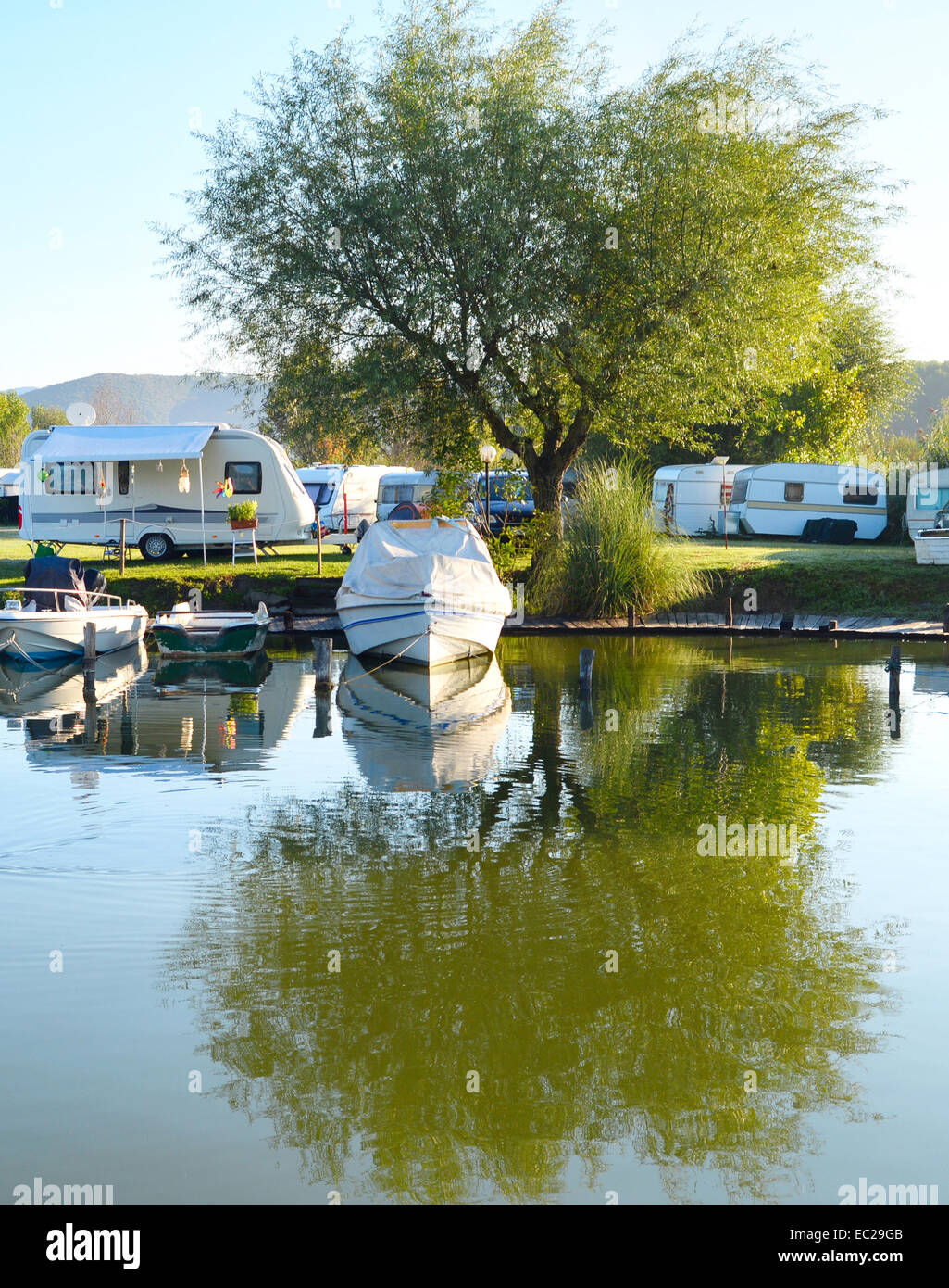 Campingplatz am See mit Wohnwagen und Boote Stockfoto