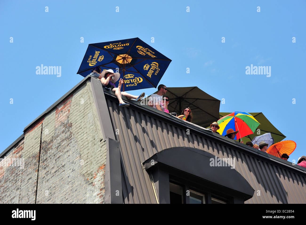 Menschen auf einem Dach Vorsprung halten, dass Schirme schauen hinunter um die Parade auf 2014 World Pride in Toronto. Stockfoto