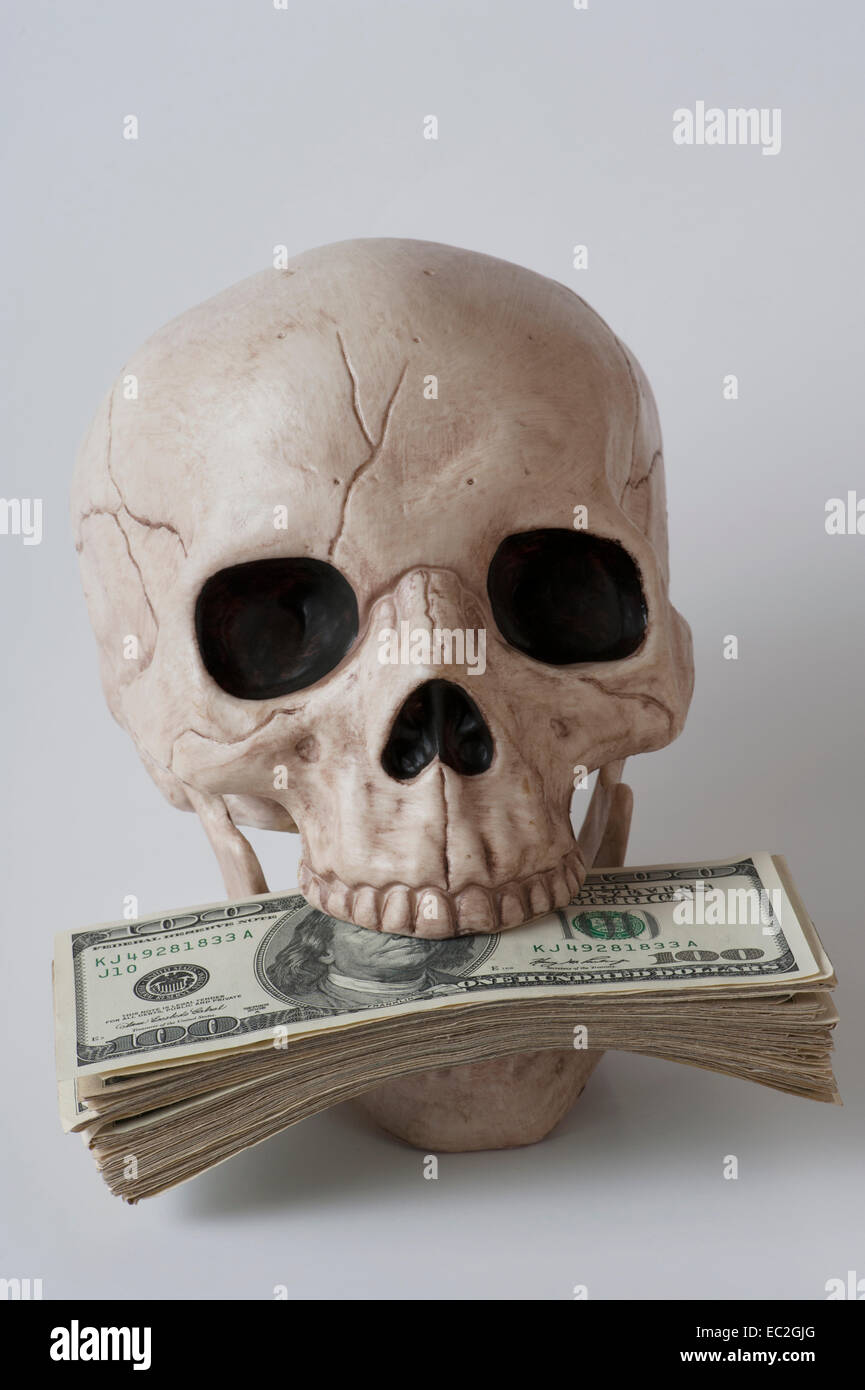 menschlicher Schädel mit $100-Dollar-Scheine in den Mund gestopft Stockfoto