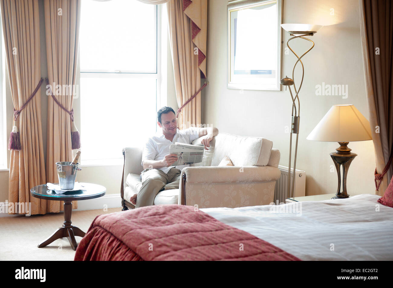 Ein Mann, der in einem Hotelzimmer im Urlaub entspannen Stockfoto