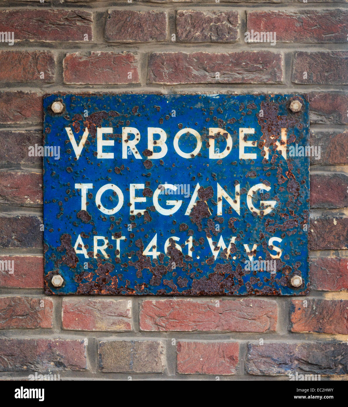 Rostige alte Platte auf Ziegelwand mit niederländischen Text "No Trespassing" Stockfoto
