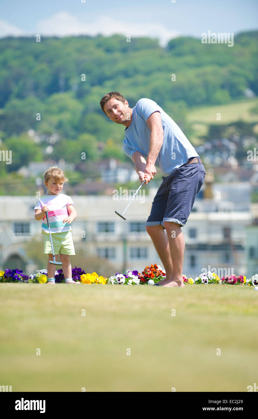 Ein Vater sein Kind zum Golfspielen zu unterrichten Stockfoto