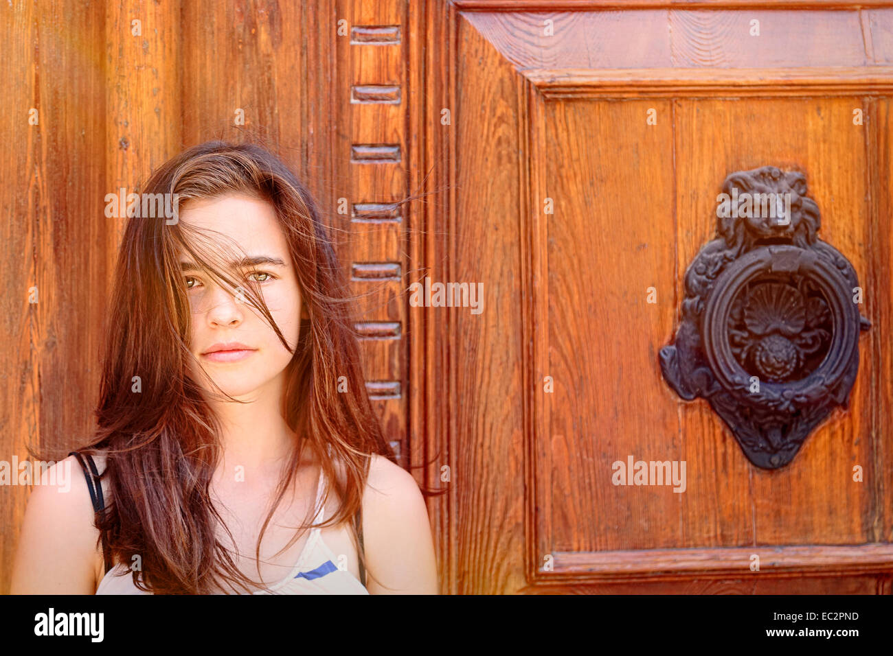 Porträt eines schönen Mädchens vor einer alten Holztür Stockfoto
