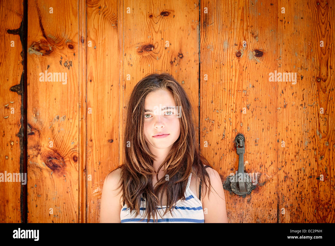 Porträt eines schönen Mädchens vor einer alten Holztür Stockfoto
