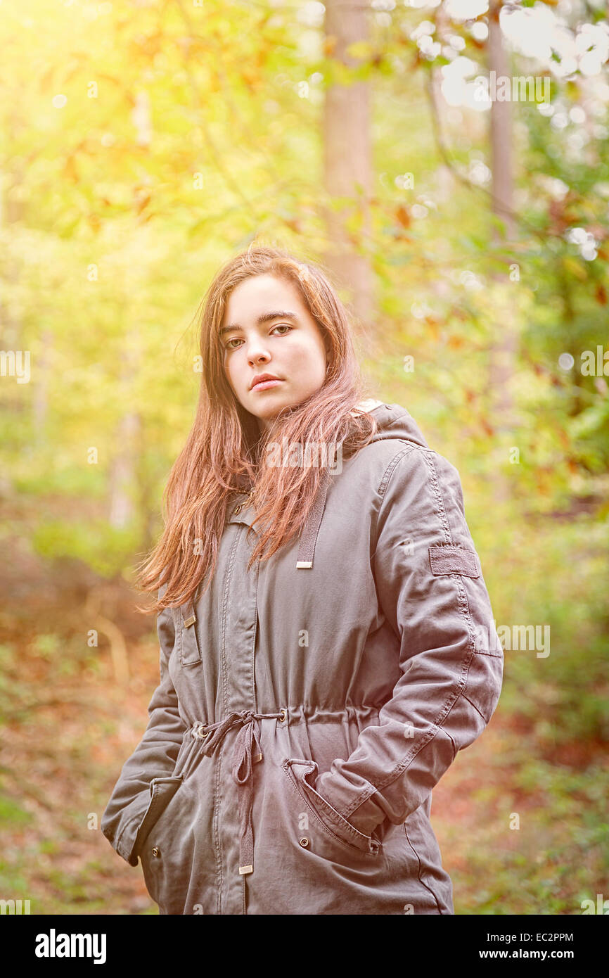 Porträt von einem Teenager-Mädchen mit grünen Parka in einem herbstlichen Wald Stockfoto