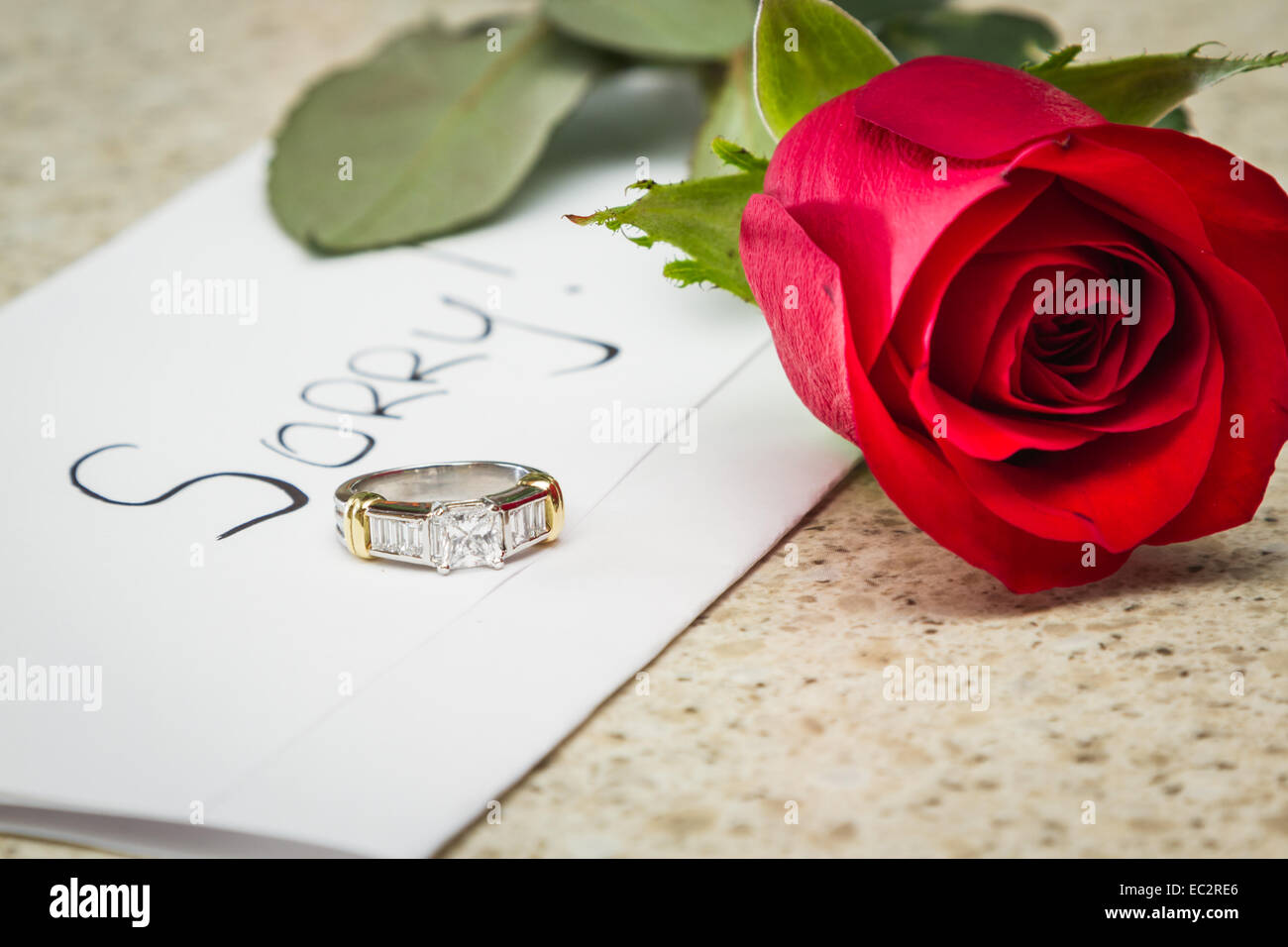 Konzept einer verlorenen Beziehung mit einen Brief, eine rote Rose und einen Verlobungsring links auf einem Tisch Stockfoto