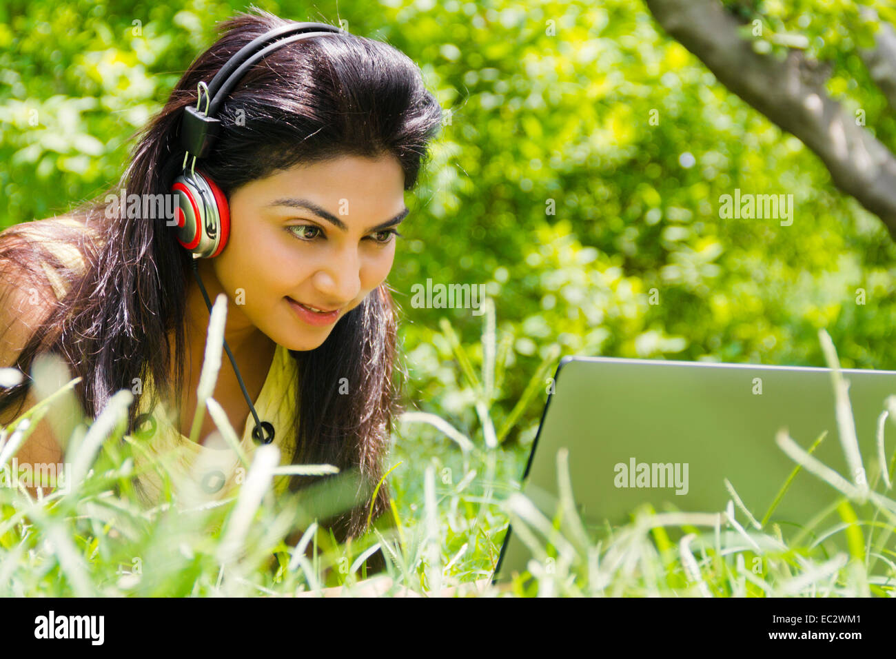 indische wunderschöne Dame Park hören von Musik Stockfoto