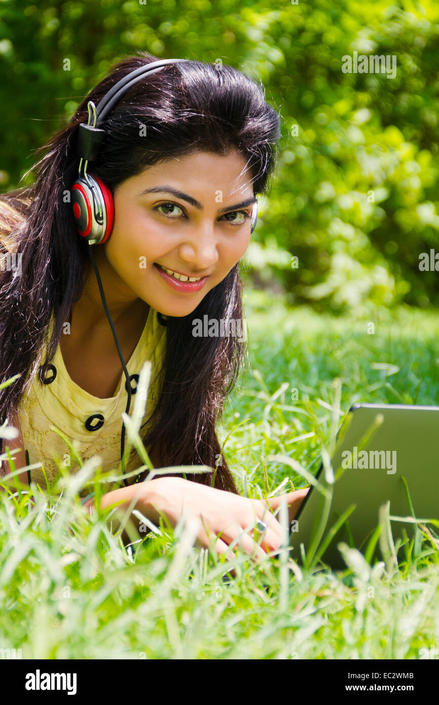 indische wunderschöne Dame Park hören von Musik Stockfoto