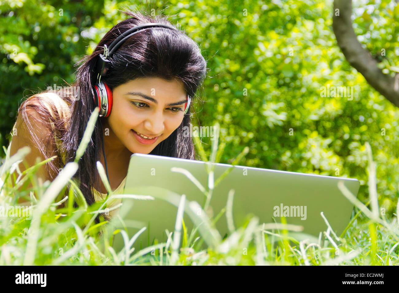 indische wunderschöne Dame Park hören von Musik Stockfoto