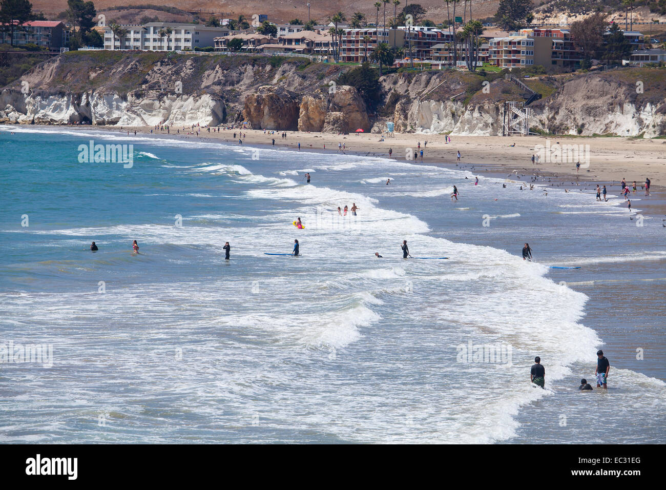 Besucher spielen in den Wellen am Pismo Beach, Central Coast, Kalifornien, USA Stockfoto