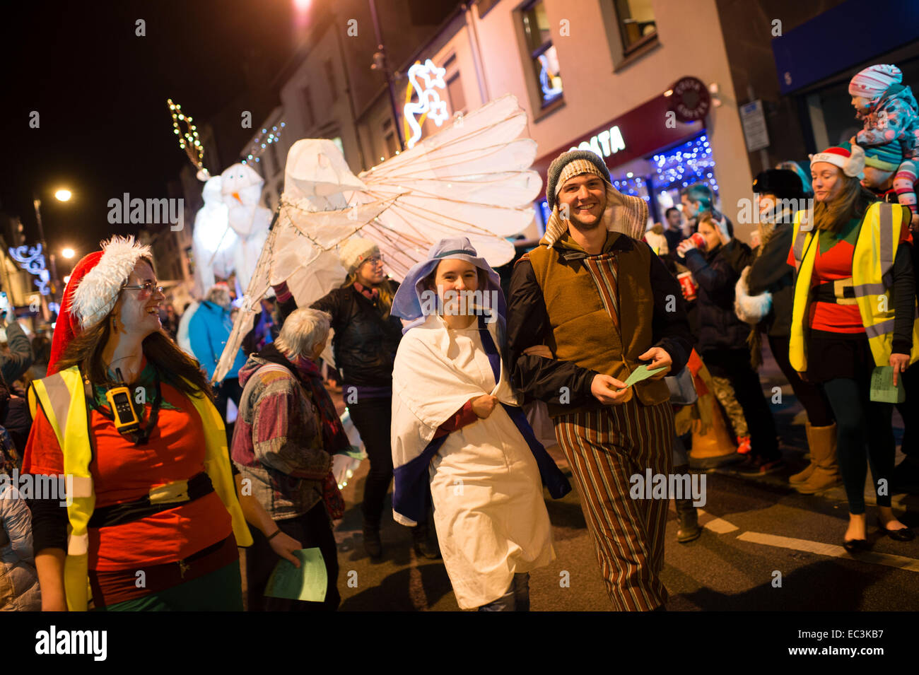 Maria und Josef Krippe Zeichen führenden Massen auf einem Laternenumzug durch die Straßen von Aberystwyth Weihnachtslichter, Wales UK Einschalten im Vorfeld Stockfoto