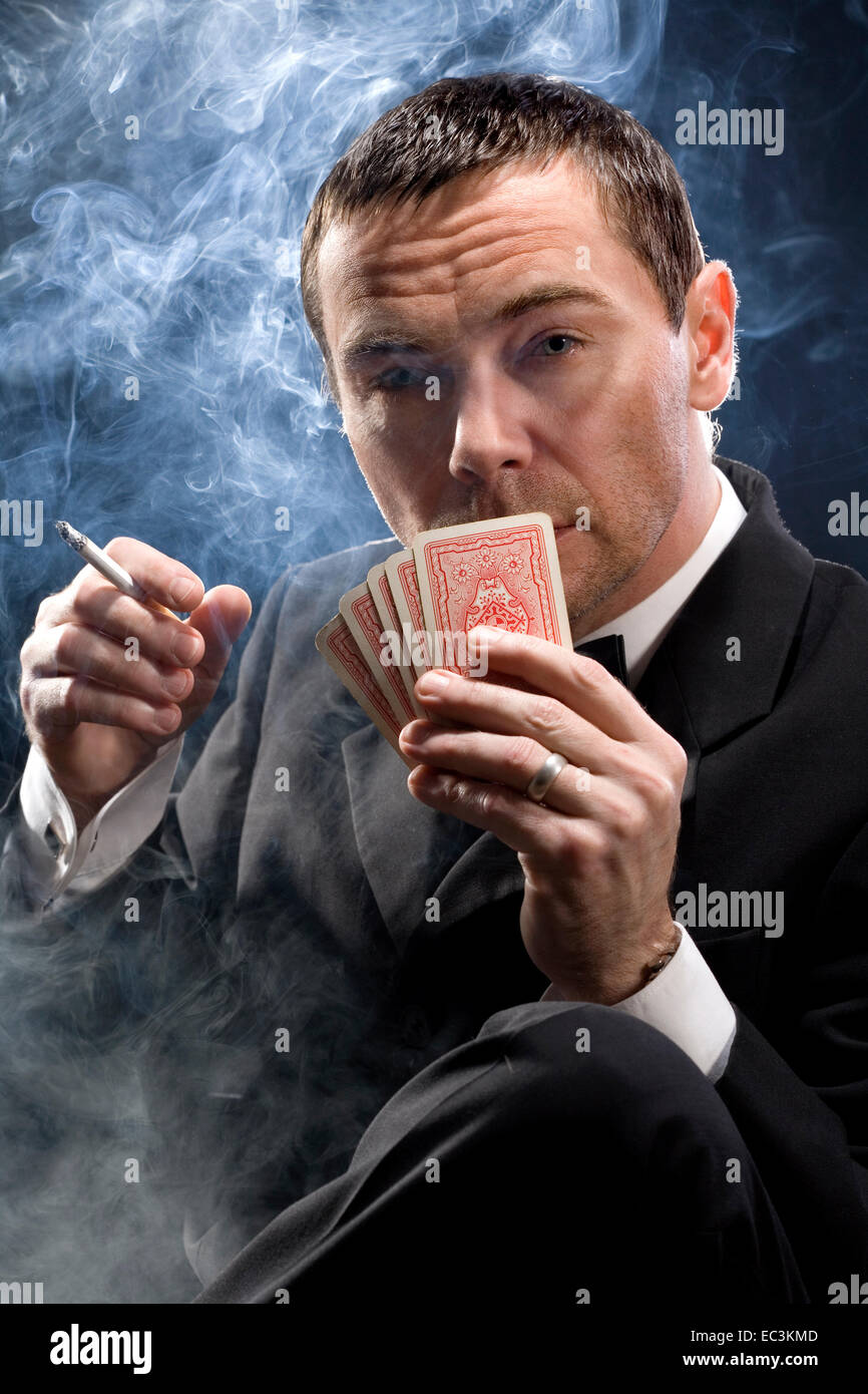 Mann mit Zigarette Spielkarten Stockfoto