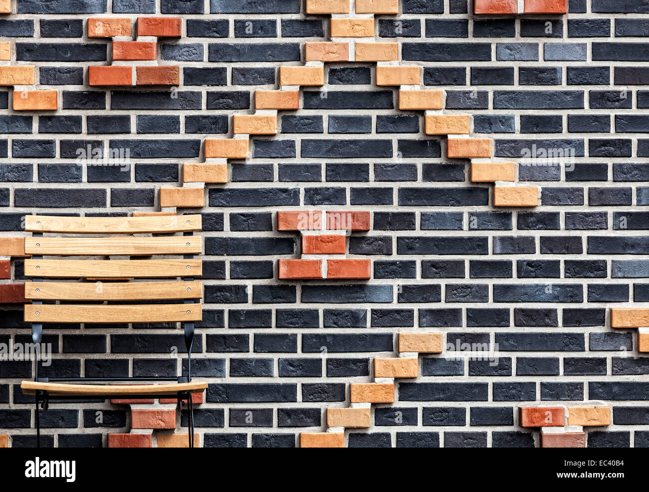 Mauer aus Ziegeln mit hölzernen Stuhl an den Rändern Stockfoto