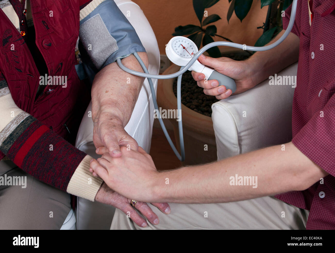 Eine Krankenschwester im Pflegeheim misst den Blutdruck Stockfoto