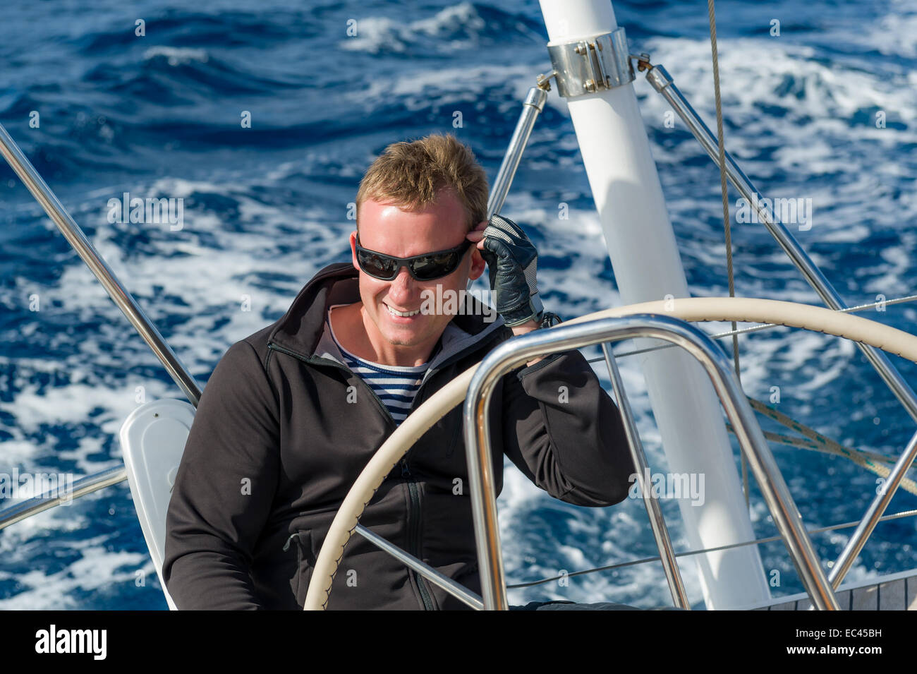 Fröhliche Skipper auf der Spitze des Segelboot Stockfoto