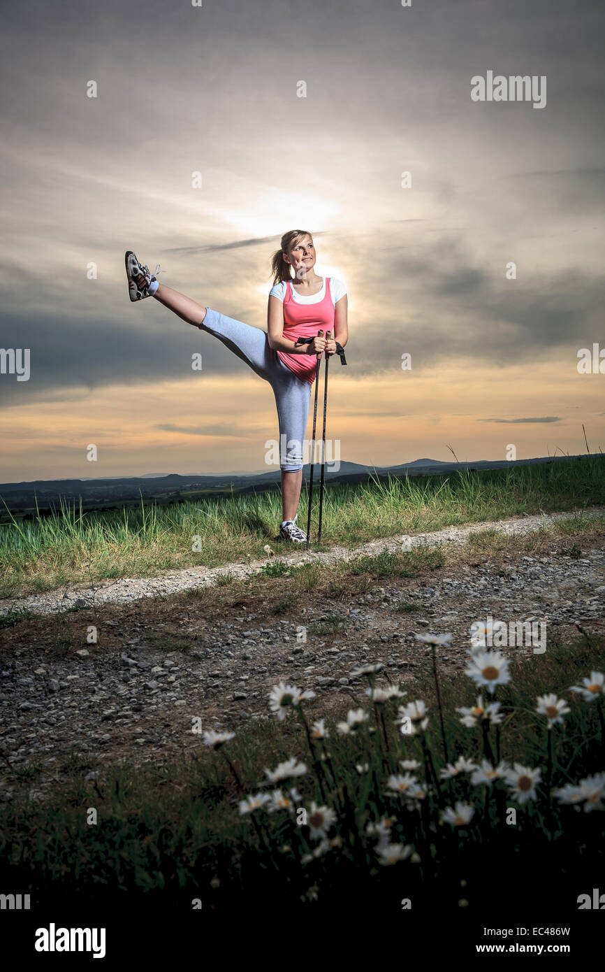 Eine junge Frau, die Strecken für nordic walking Stockfoto