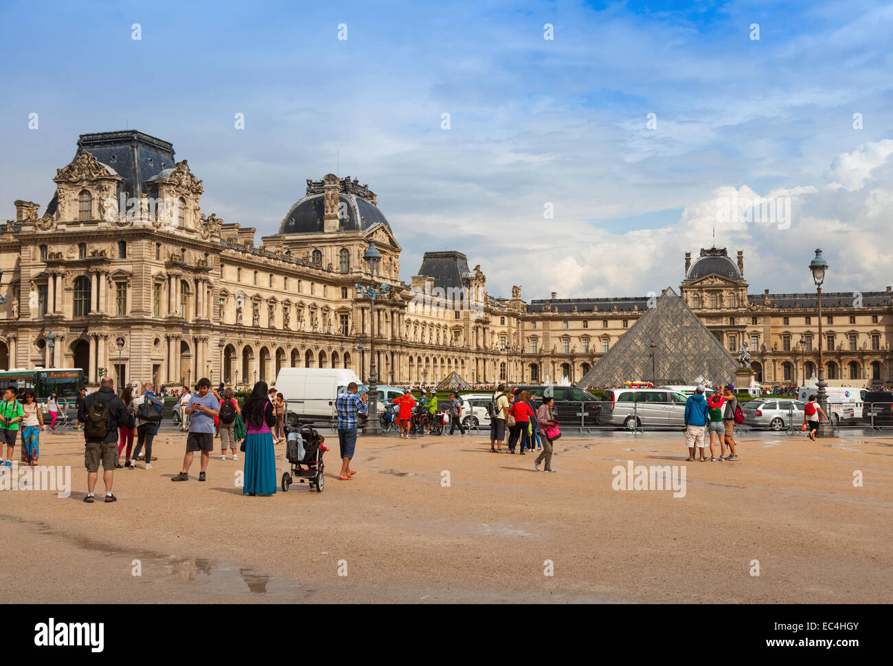 Paris, Frankreich - 7. August 2014: Fassade des Louvre Museums mit Touristen und Autos fahren auf der Straße Stockfoto